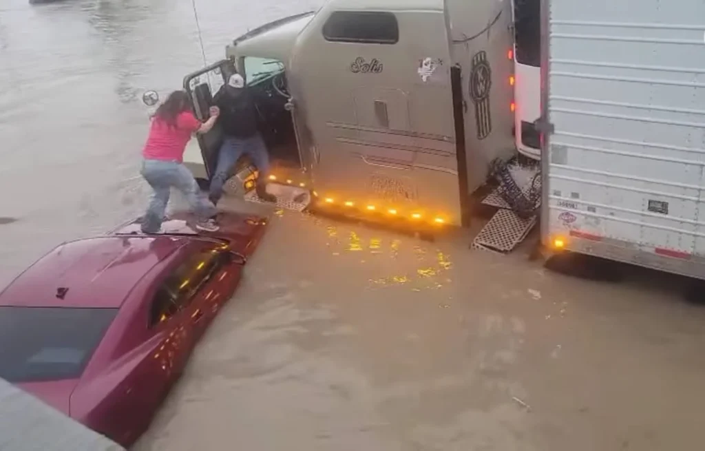 Un trailero ayuda a una mujer a ponerse a salvo en Reynosa.