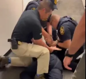 El senador Alex Padilla es esposado en el suelo.